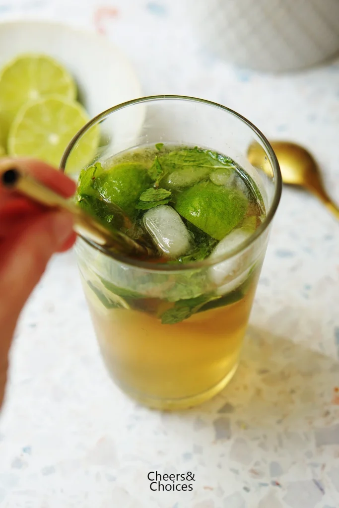 Alkoholfreier Mojito mit Minze, Limetten und Eiswürfeln in einem hohen Glas als Serviervorschlag.