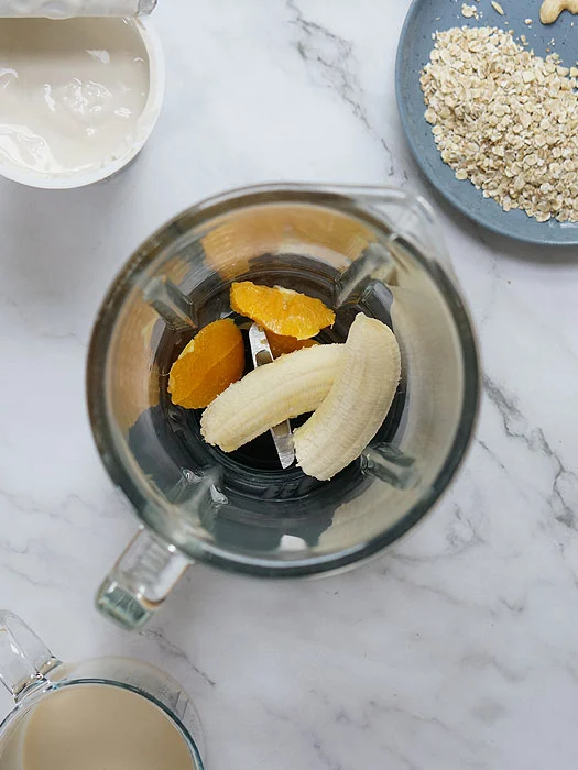 Bananen und Orangen im Mixer.