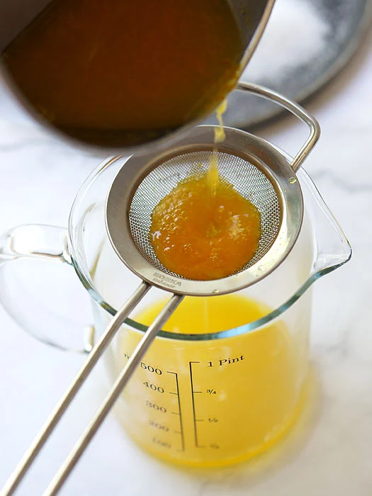 Orangen-Sirup durch ein Sieb gegossen.