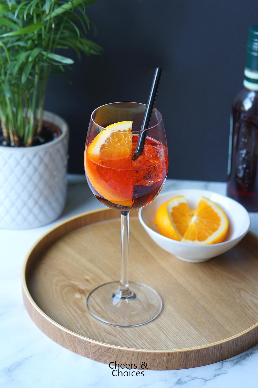 Alkoholfreier Aperol Spritz auf einem Holztablett.